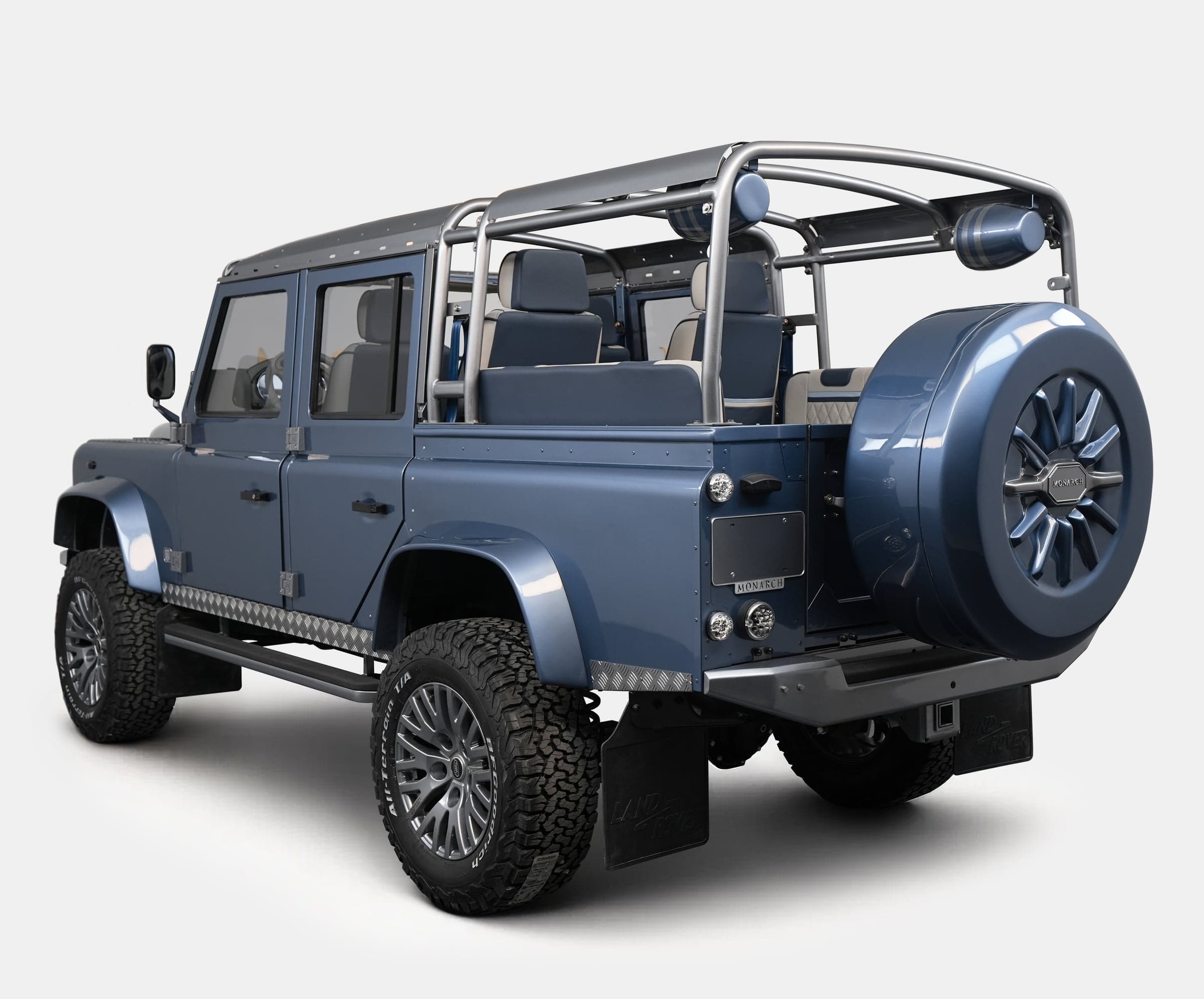 Rear View: Bespoke Land Rover Defender Rear view of a custom blue Land Rover Defender with a stylish spare tire and luxurious seating