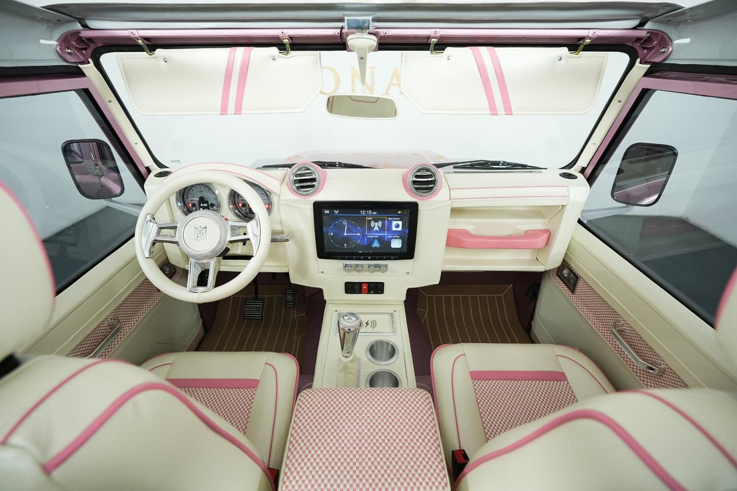Interior Shot: Custom Luxury Cabin Bespoke Land Rover Defender interior featuring cream and pink leather, modern dashboard, and touchscreen display