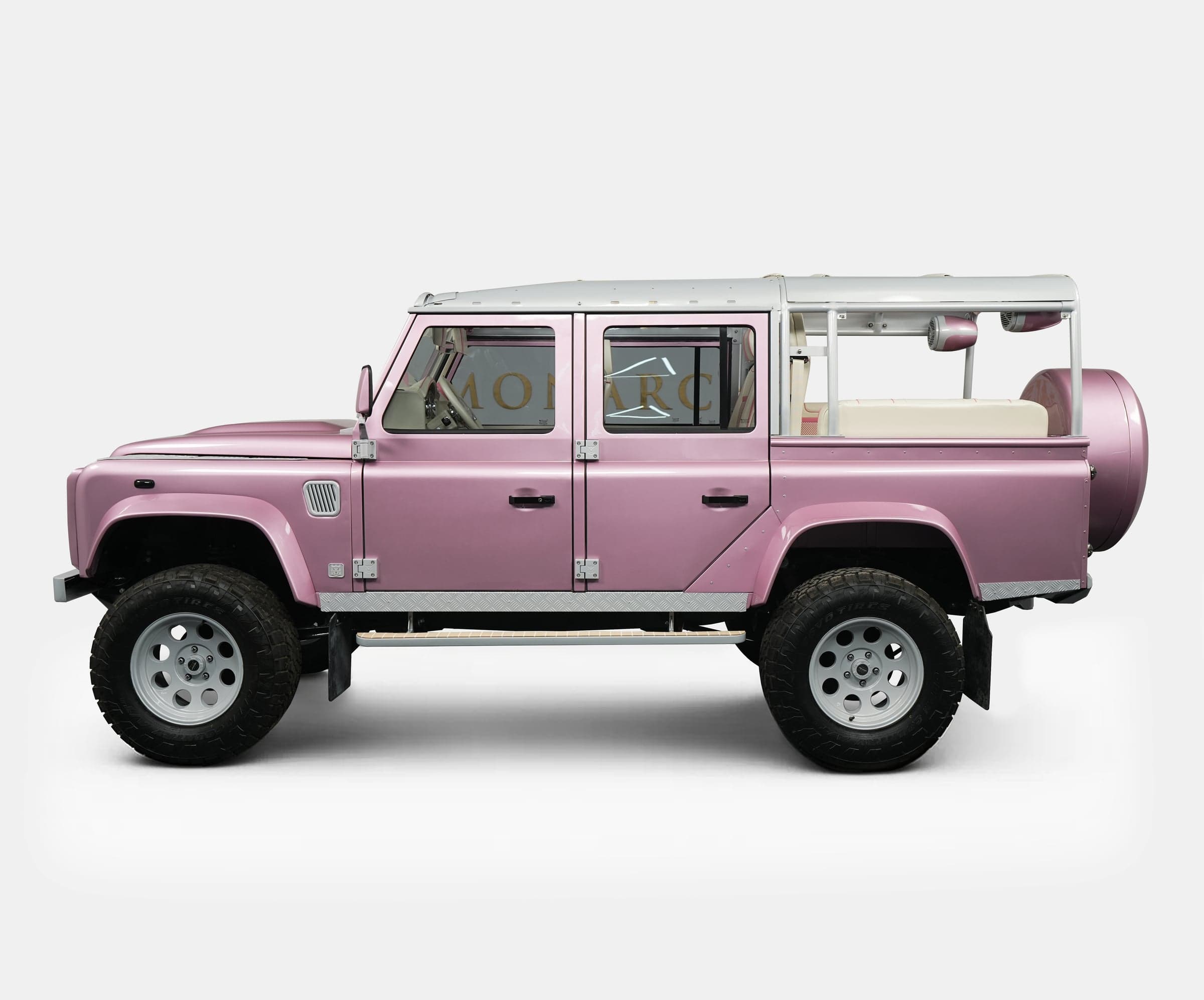 Side View: Bespoke Land Rover Defender Side view of a custom pink Land Rover Defender showcasing luxury design and off-road capabilities