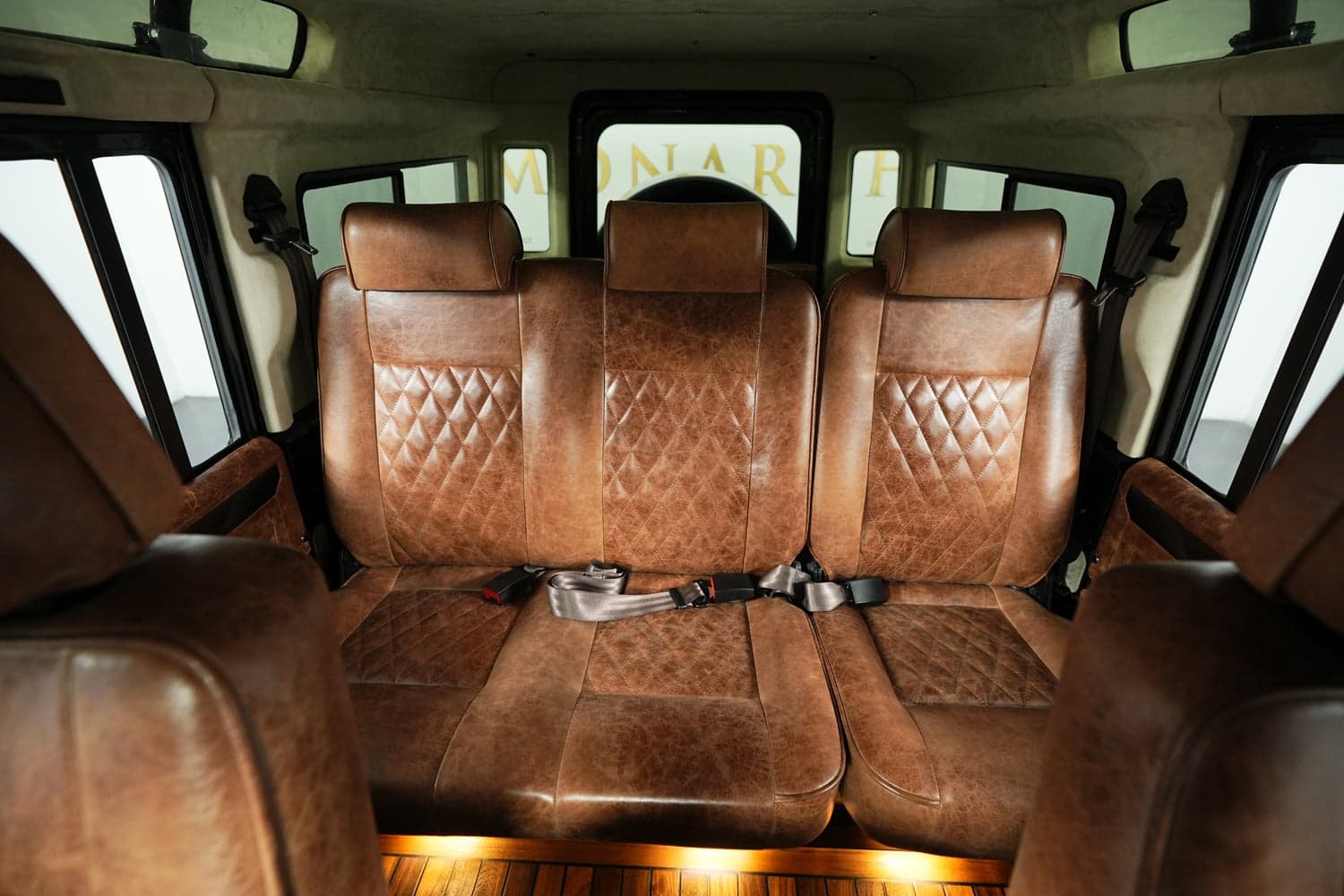 Interior Shot: Luxurious Rear Seating Luxurious brown leather rear seats with diamond stitching in a custom Land Rover Defender